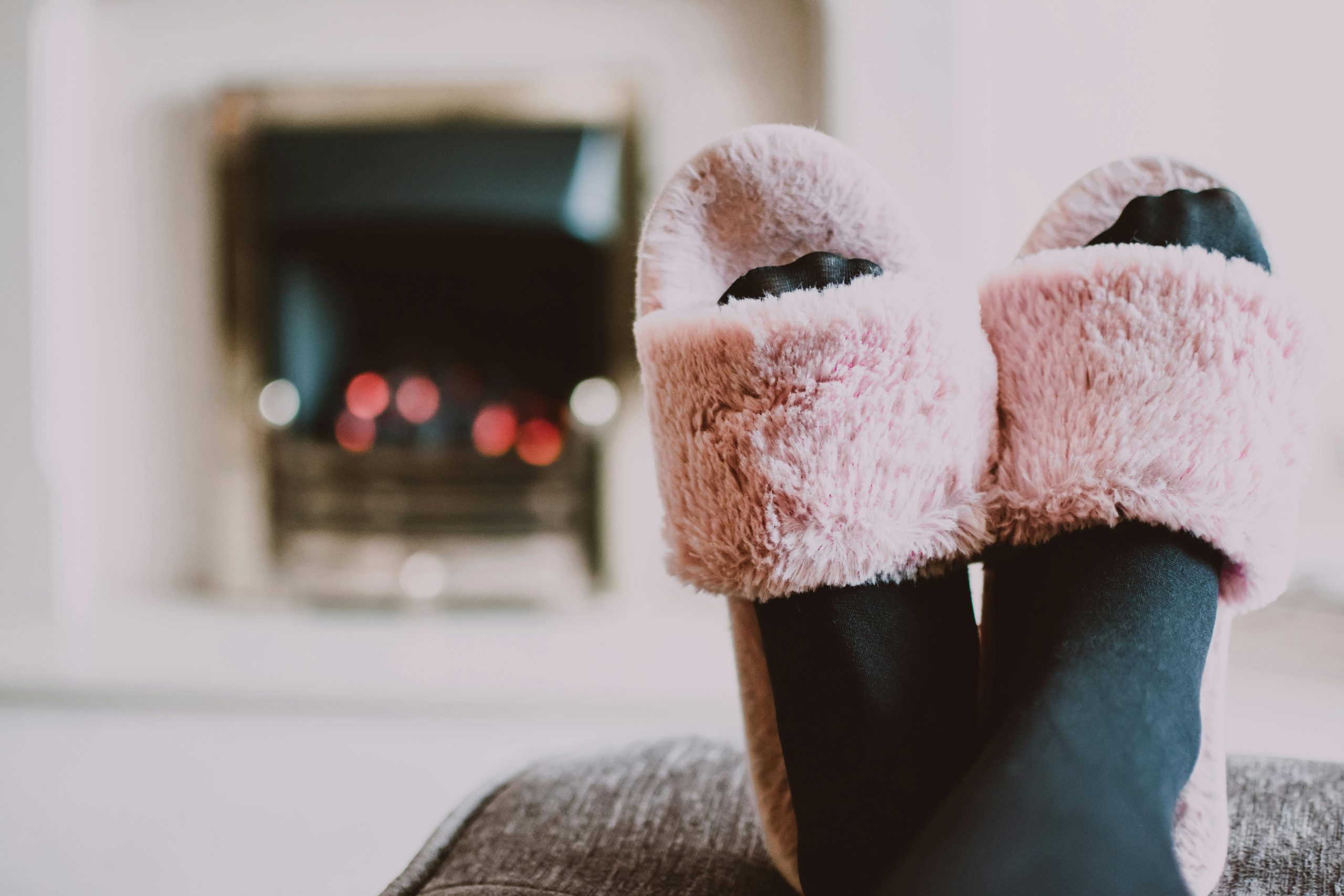 Relaxing by the fireplace with fuzzy slippers and warm socks indoors.